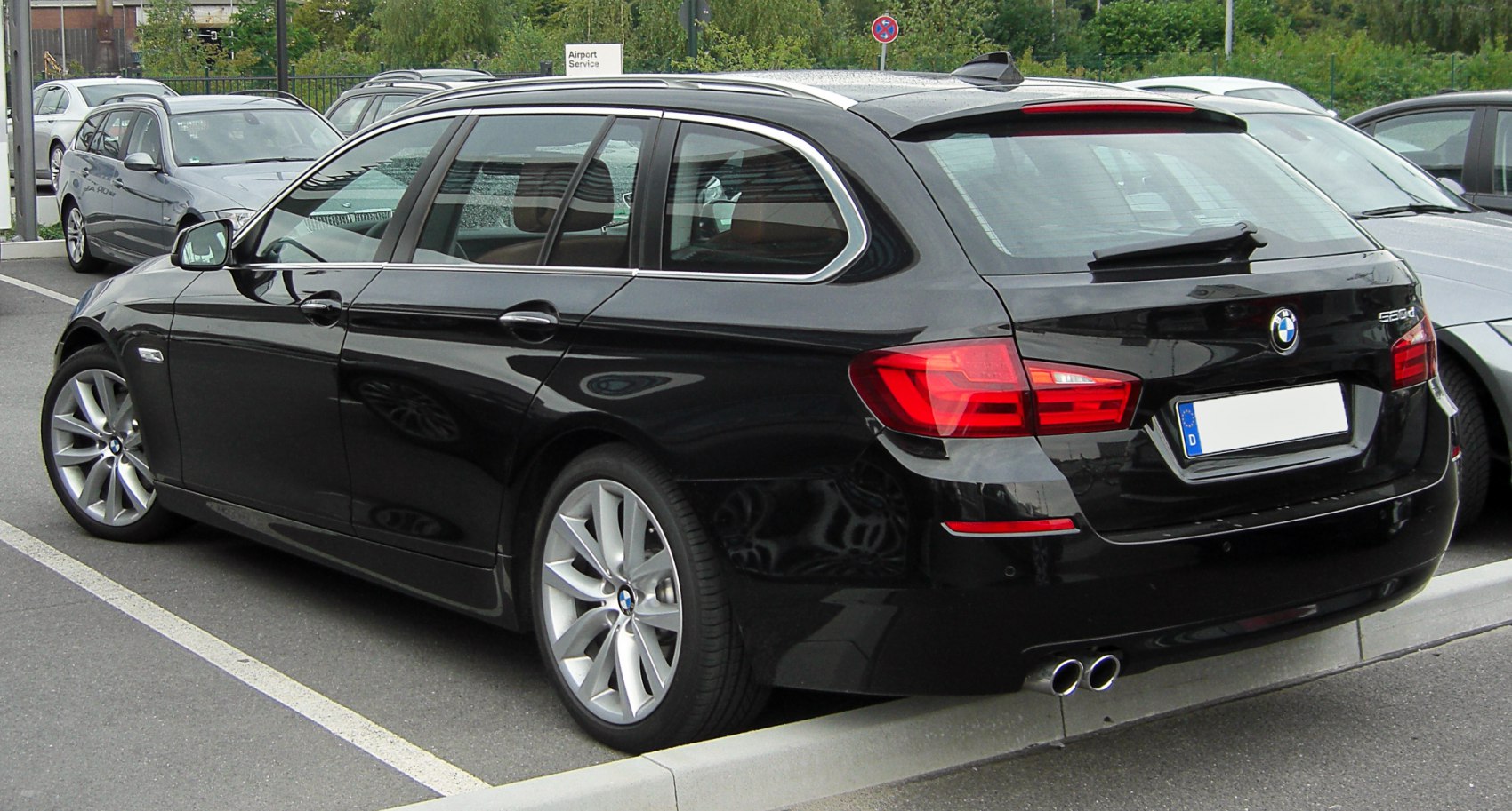 Rear side exterior of black station wagon with dual exhaust