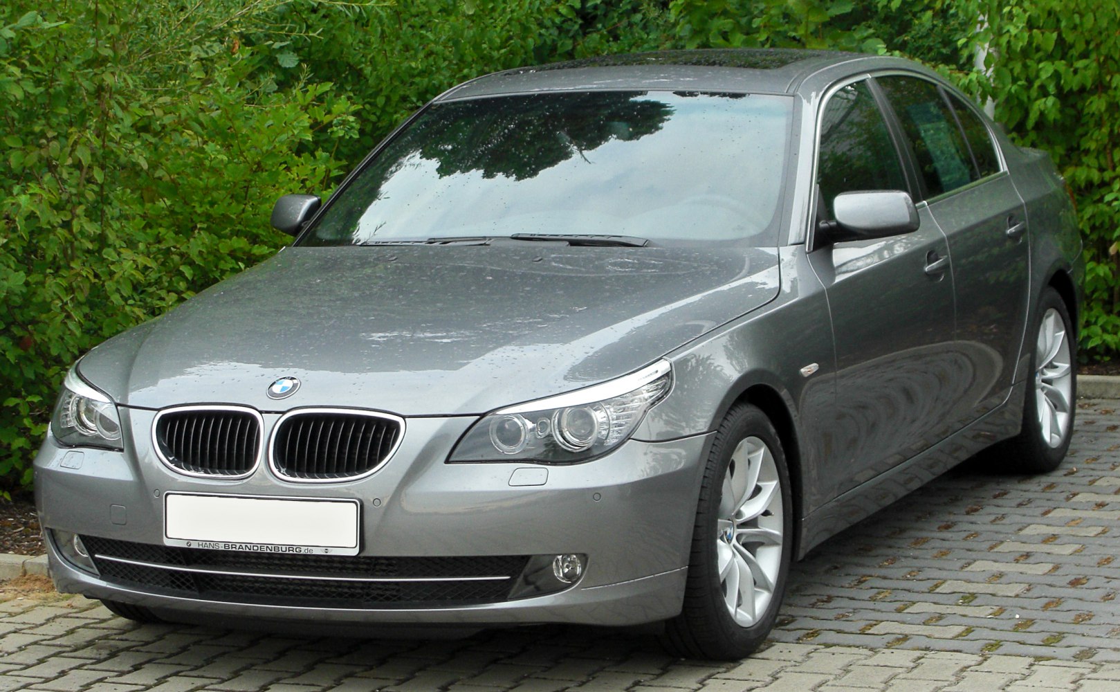 Front angled view of a grey luxury sedan with distinctive headlights and kidney grille