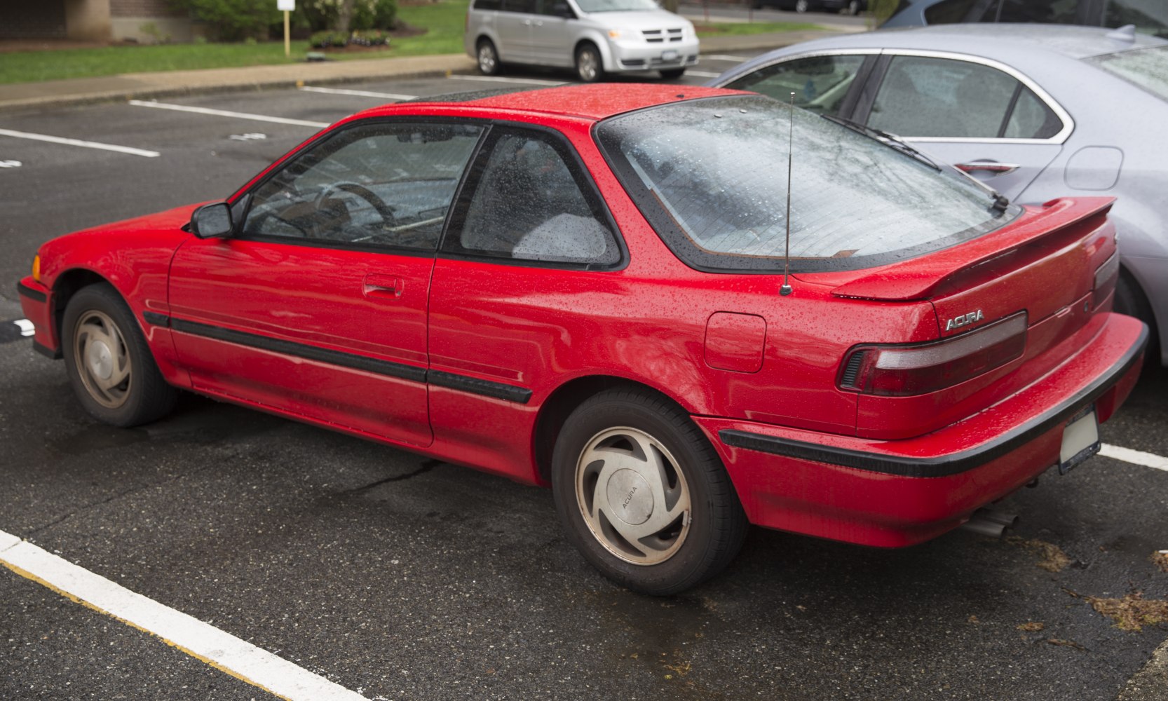 Red hatchback with rear spoiler and black side trim