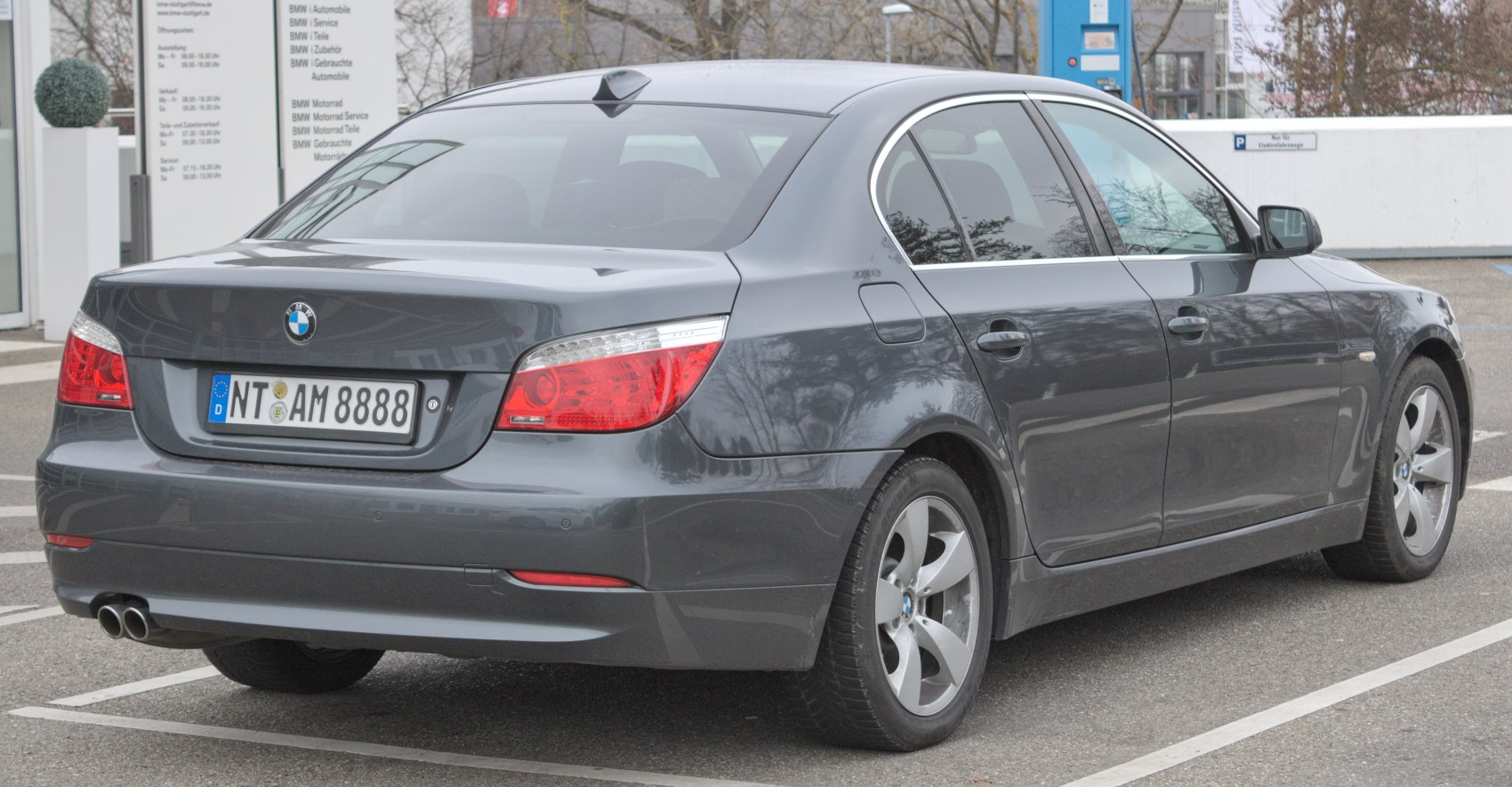 Rear view of a sedan showing tail lights, dual exhaust, and a shark fin antenna