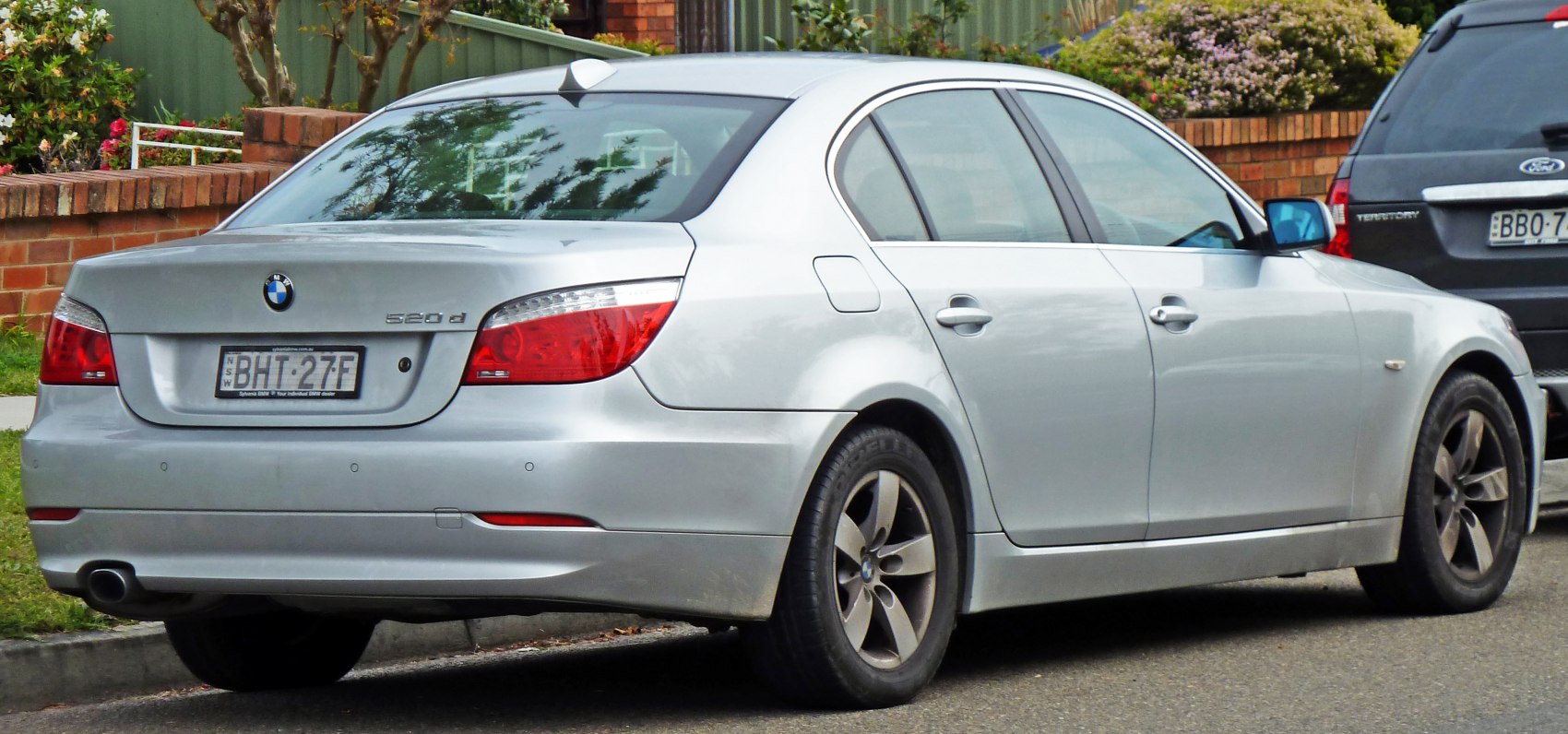 Silver sedan rear and side profile with distinctive taillights and alloy wheels