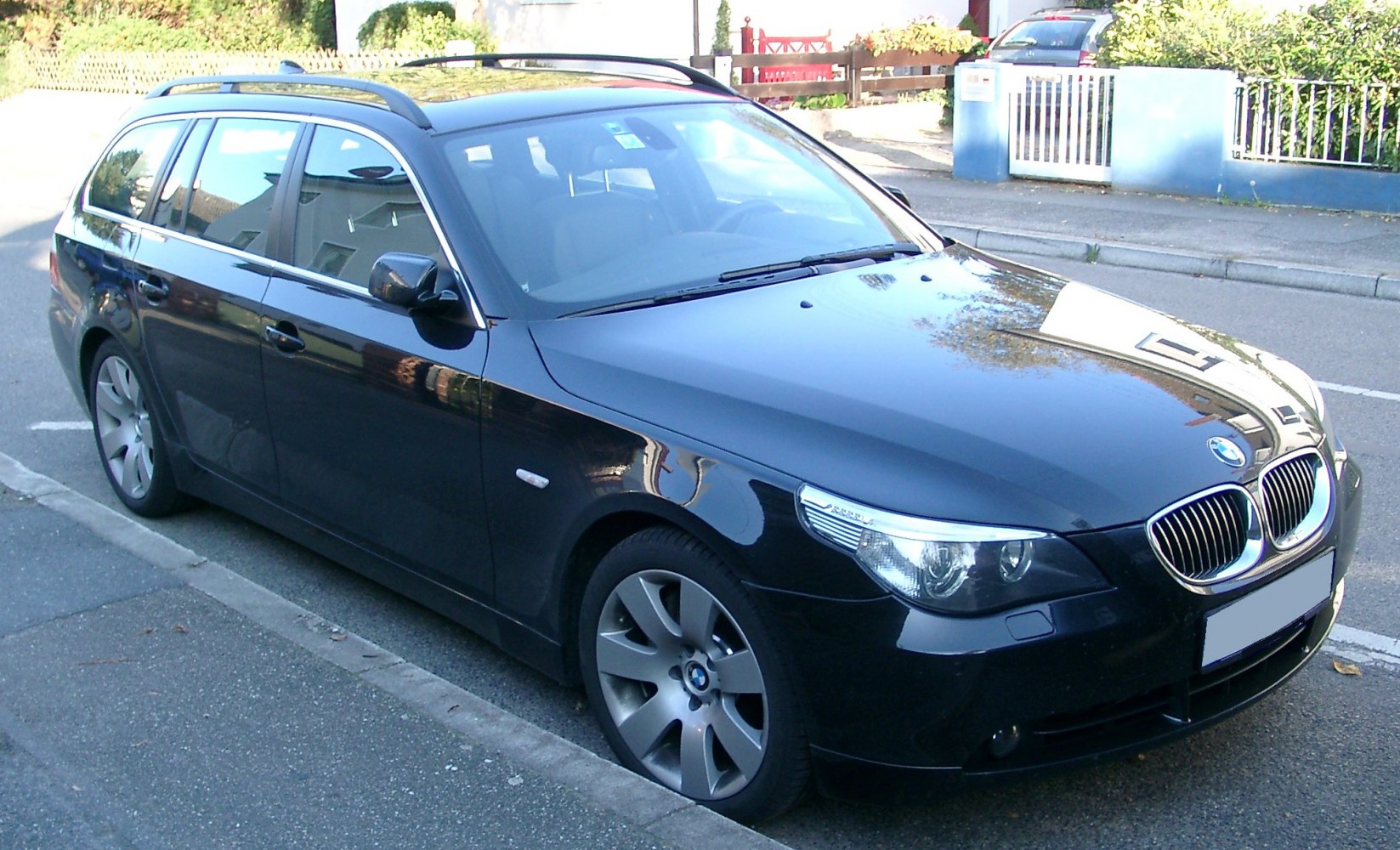 Front-side view of a black station wagon with alloy wheels.