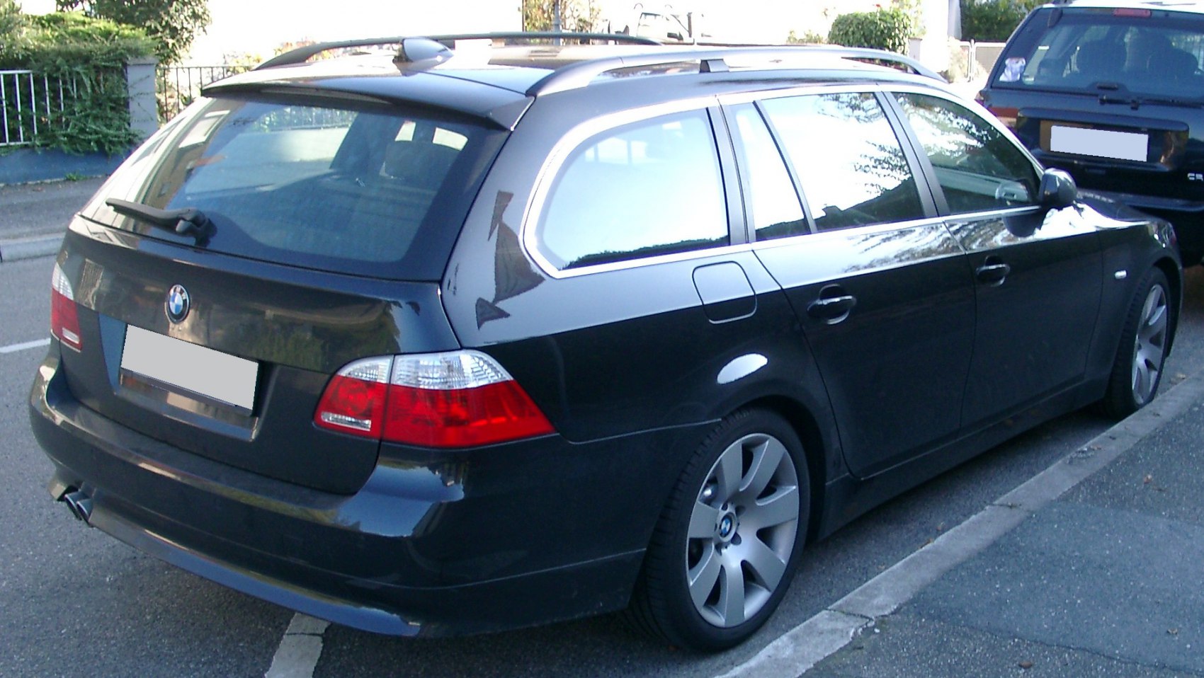 Rear and side view of a station wagon with alloy wheels and roof rails.