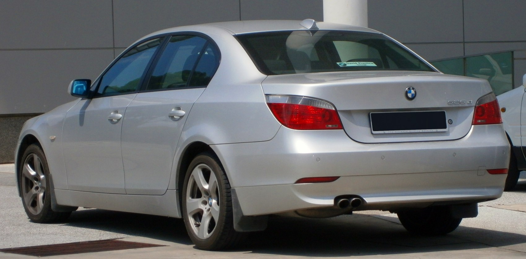Rear sedan view with dual exhaust and clear red taillights