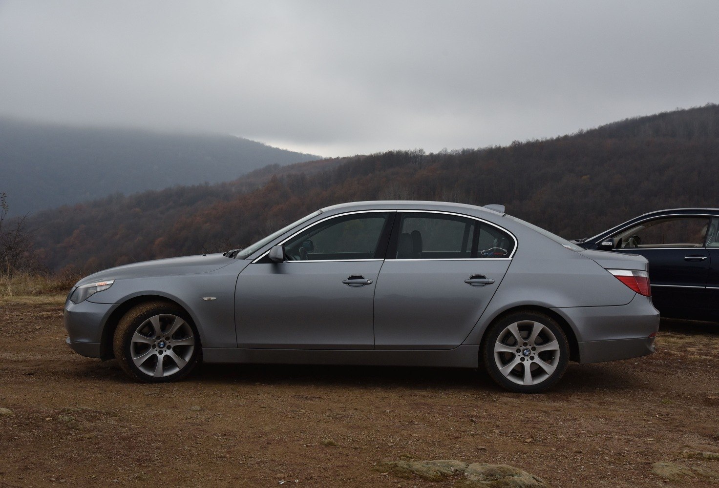 Side profile of a silver luxury sedan with five-spoke alloy wheels.