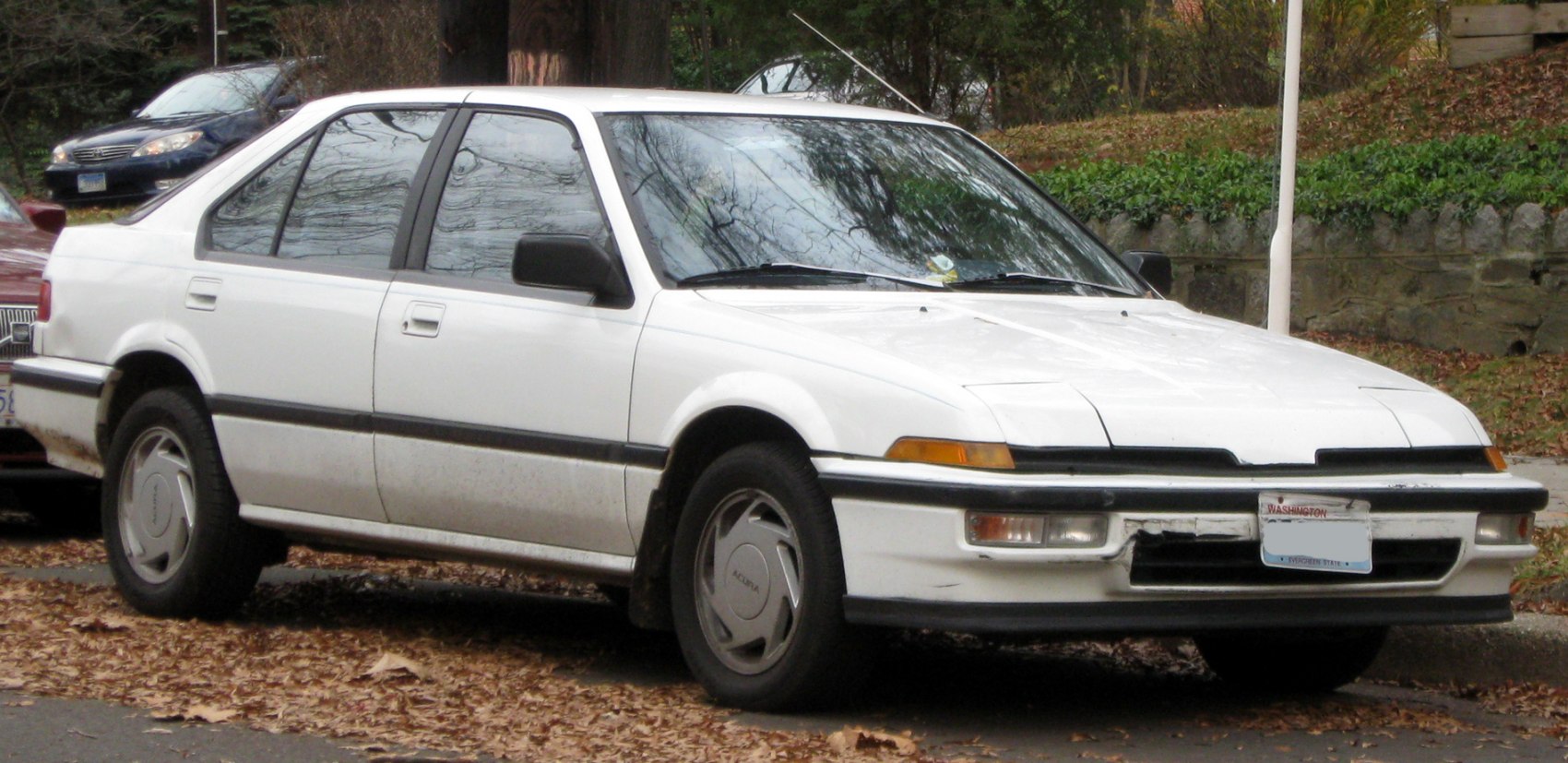White hatchback with pop-up headlights and classic 1980s sedan styling