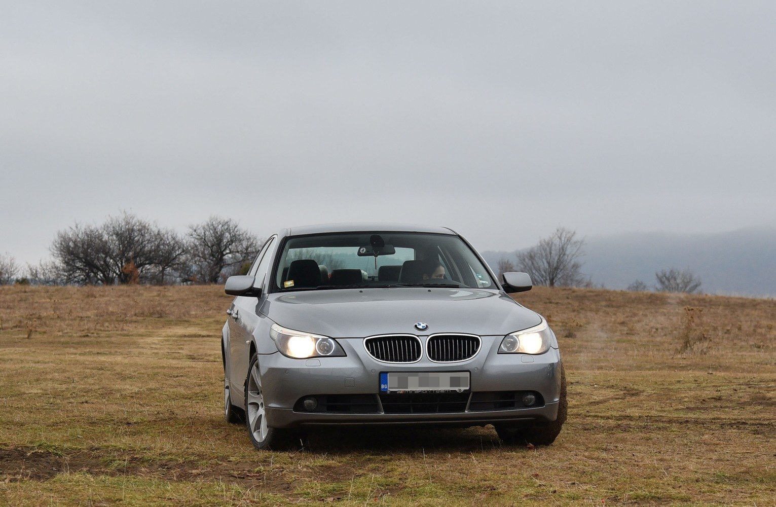 BMW 5 Series E60 front view with headlights on and kidney grille.