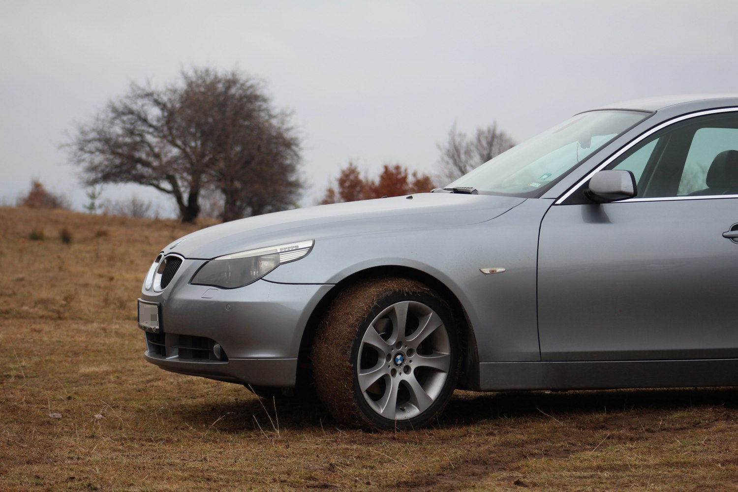 Front side view with headlight and muddy tire on rough terrain