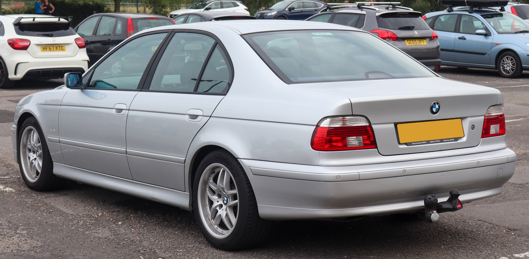 Silver sedan rear and left side view with distinct tail lights and alloy wheels