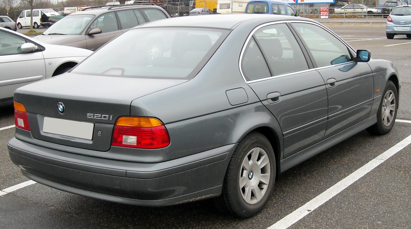 Rear side view of a grey sedan with distinct tail lights and alloy wheels