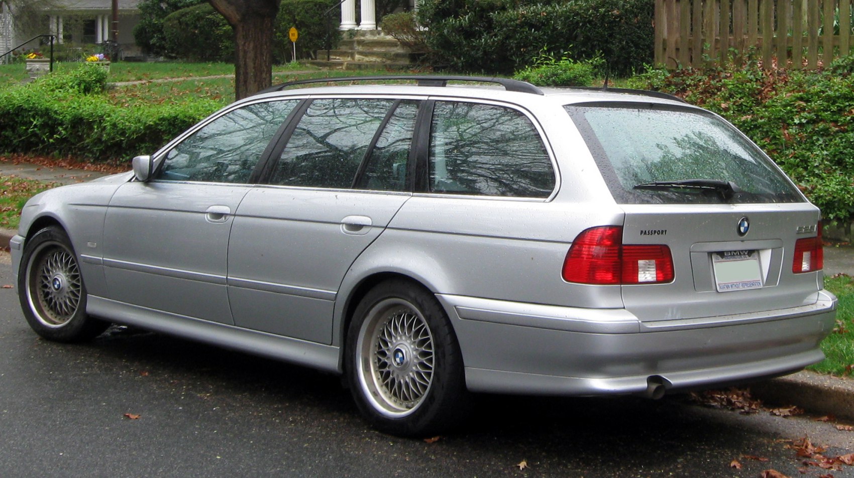 Silver station wagon rear view with multi-spoke wheels and roof rails