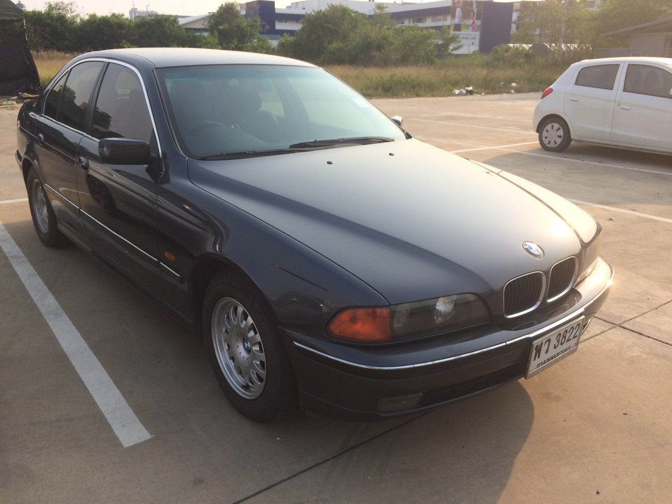 Front side view of a black sedan with kidney grille and alloy wheels