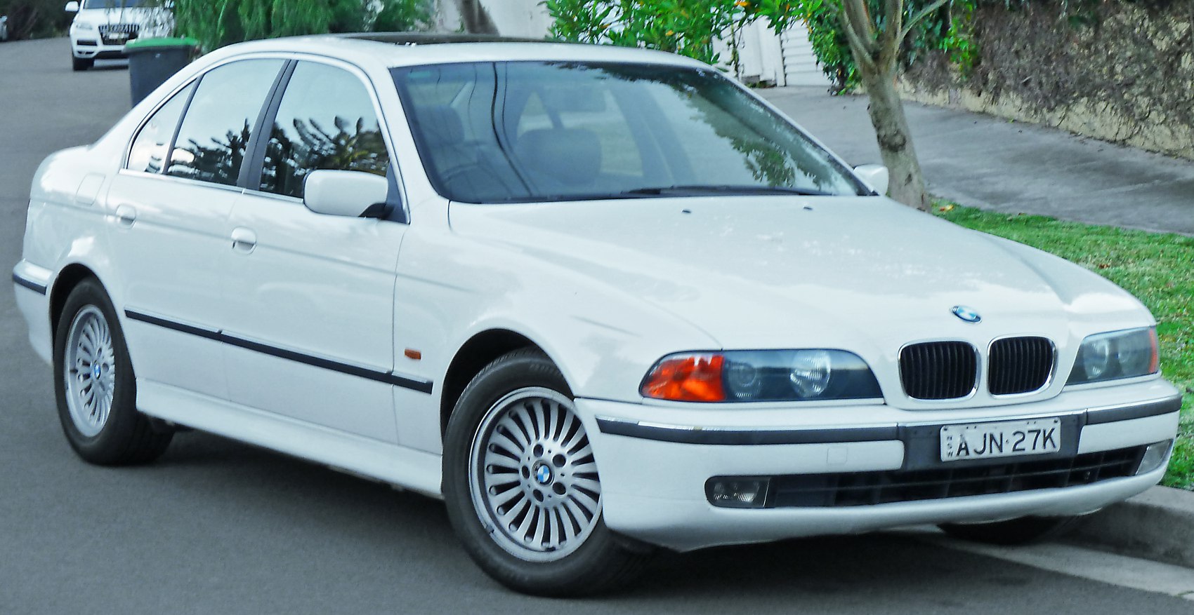 White sedan with classic BMW kidney grille, alloy wheels, and four-door design.