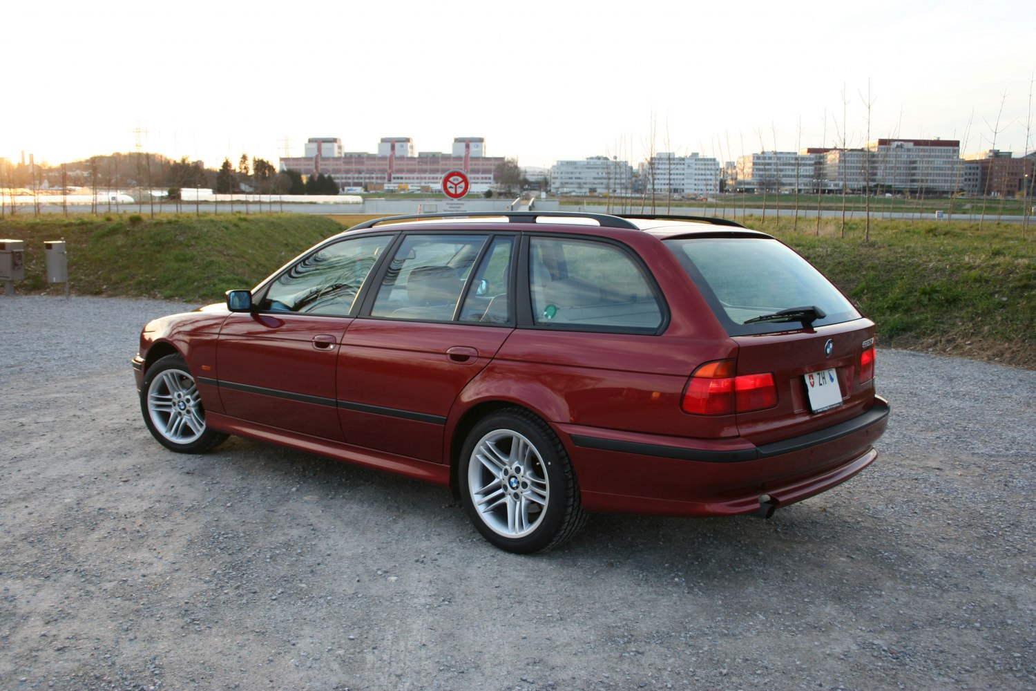 Rear side view of an estate with alloy wheels on gravel.