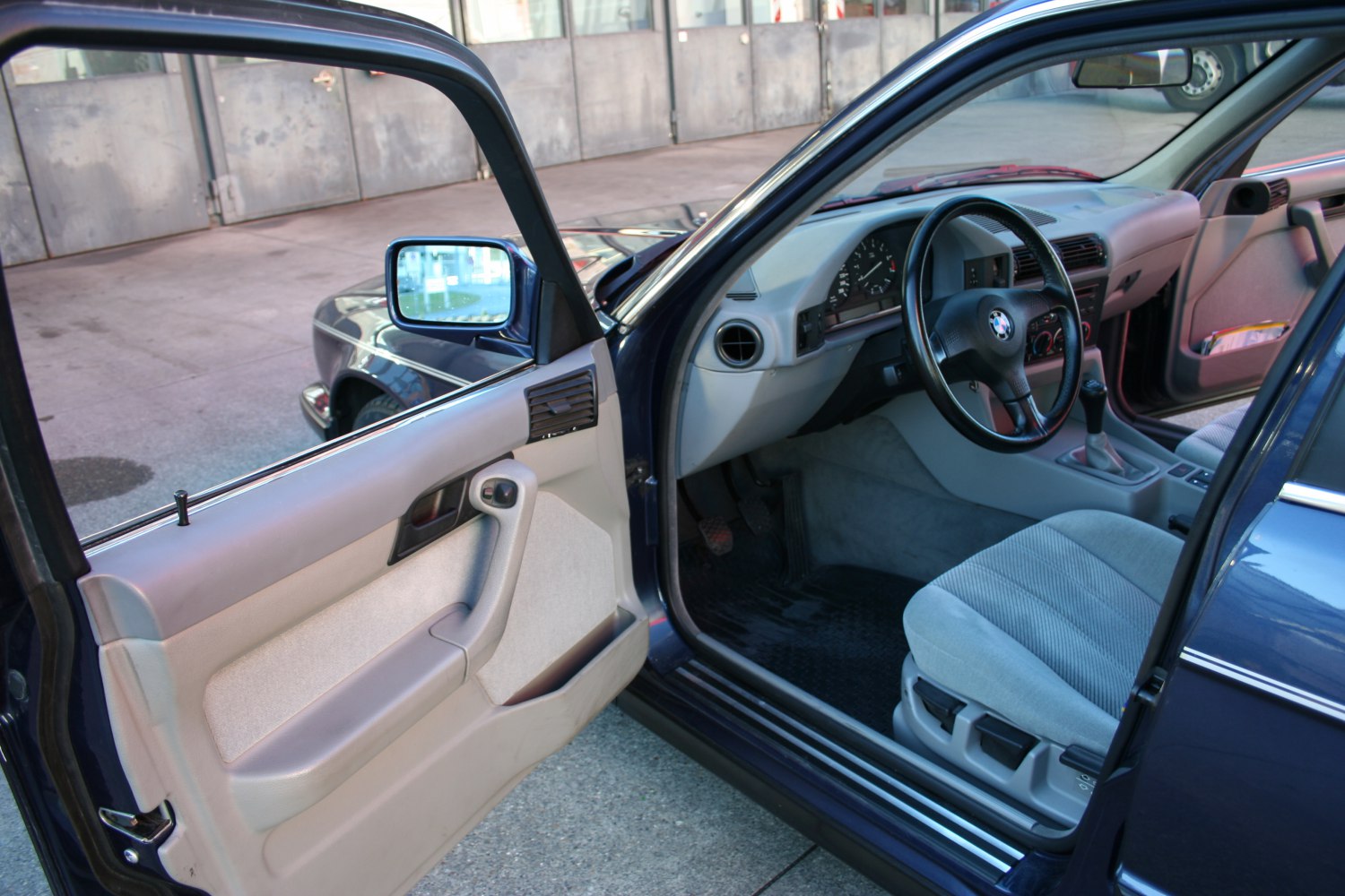 Classic car interior with steering wheel, cloth seat, and door panel