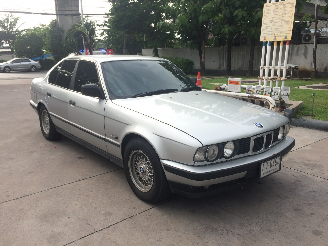 Front side view of a vintage sedan with dual round headlights and mesh wheels
