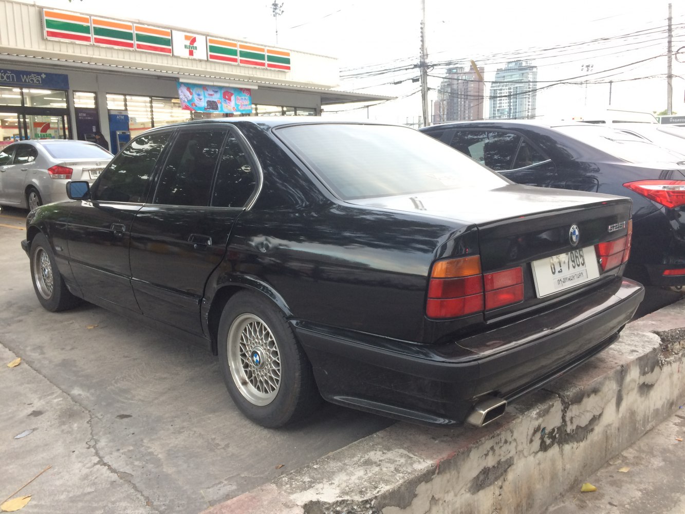Rear view of a classic sedan with mesh wheels and distinctive taillights