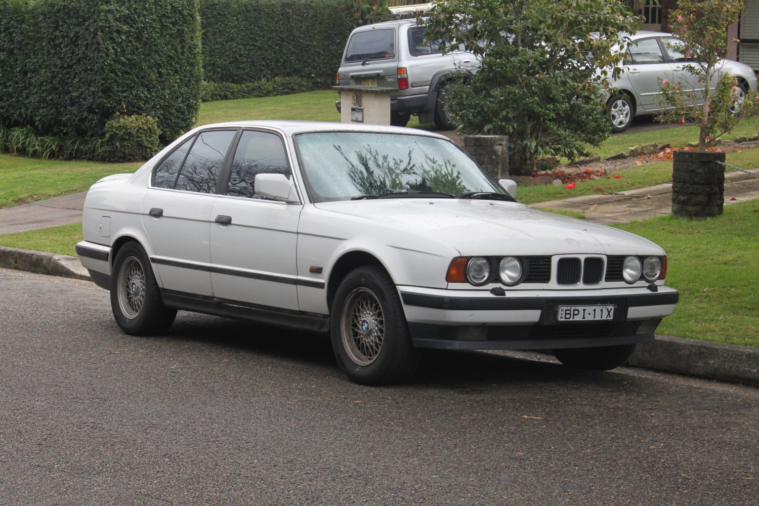 Classic sedan front side with round headlights and mesh alloy wheels