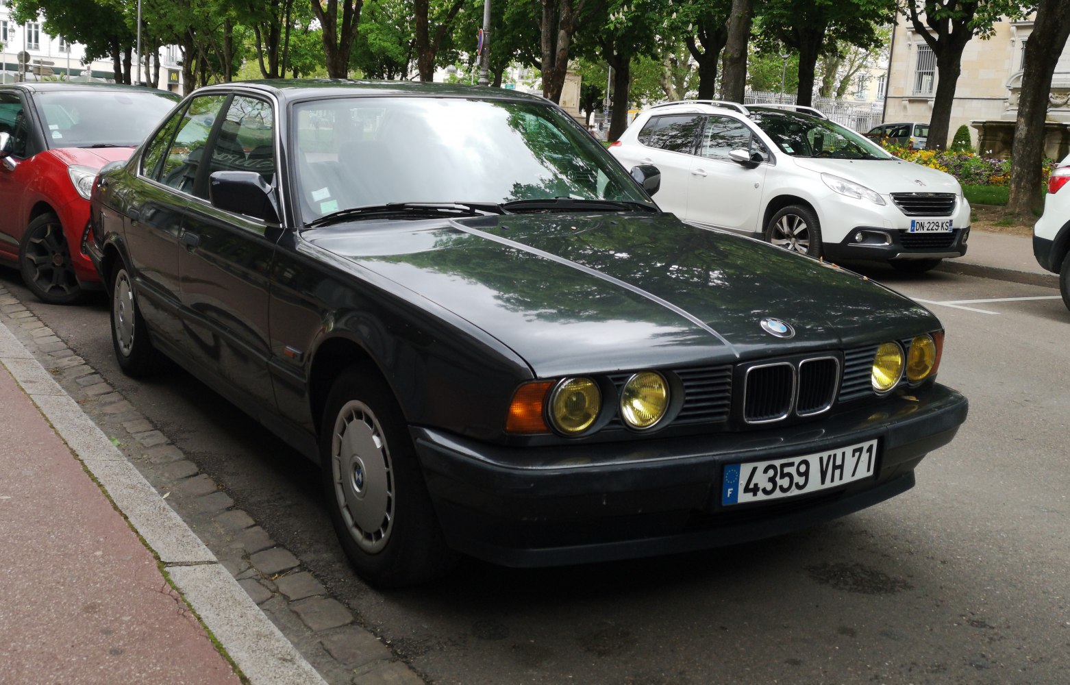 Front view of vintage car with round yellow headlights and classic grille