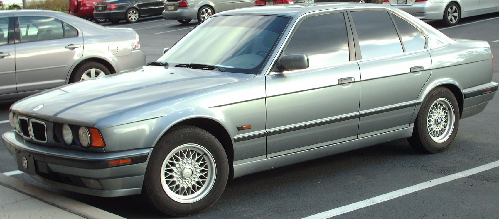 Vintage sedan with quad headlights and multi-spoke alloy wheels