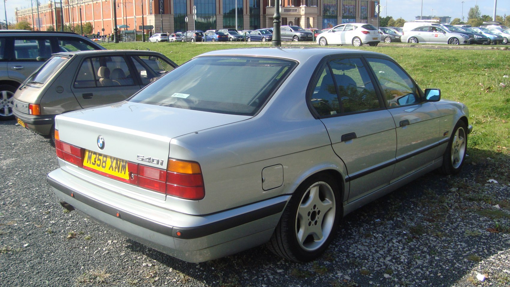 Silver sedan rear view with alloy wheels and distinct tail light design.