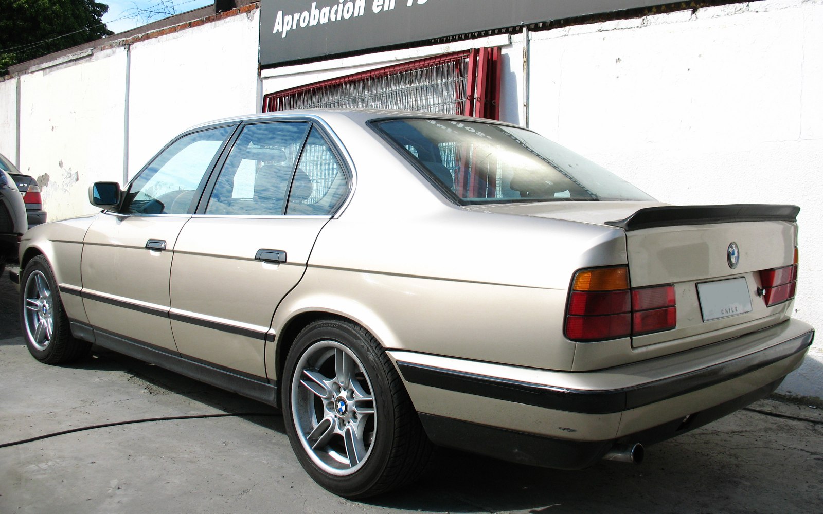 Rear side view of sedan with alloy wheels and rear spoiler