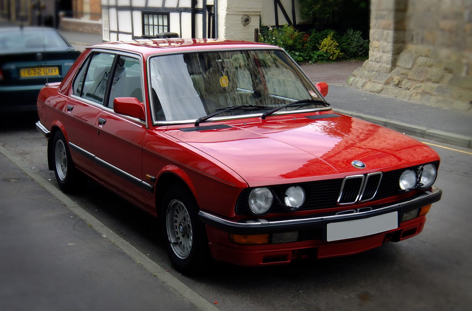 Red vintage sedan with quad headlights and alloy wheels