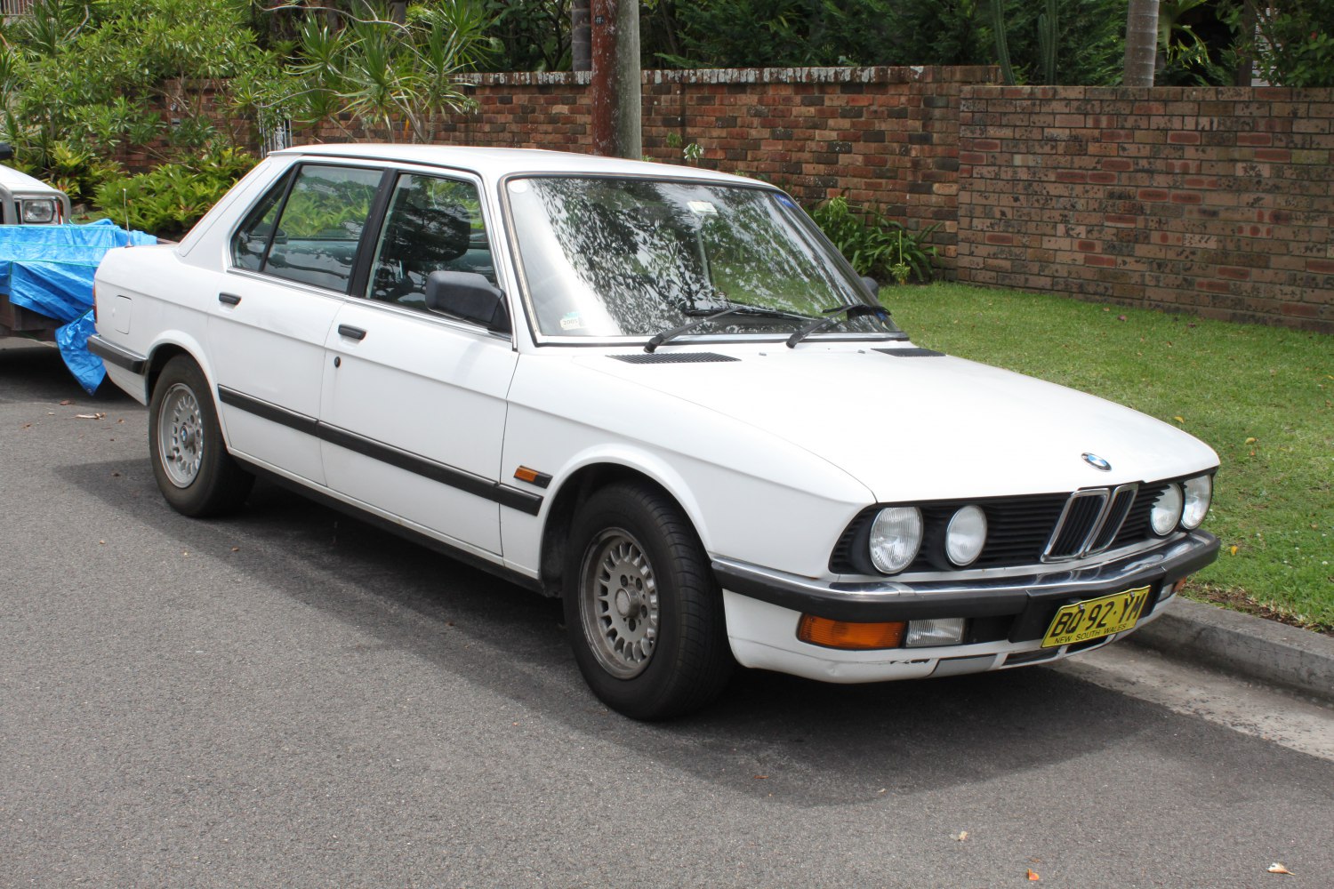 Classic white sedan with vintage front grille and round headlights
