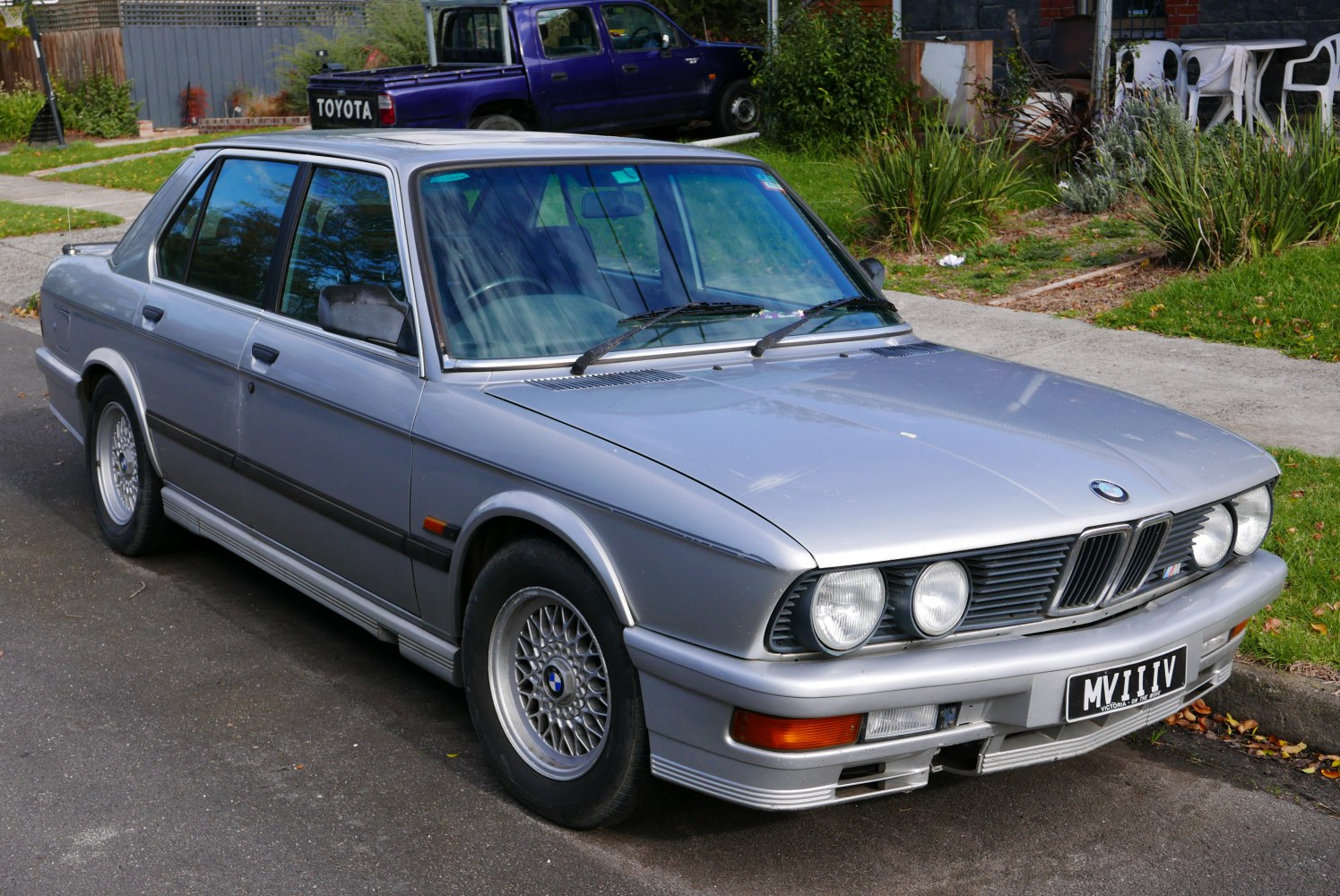 Front quarter view of classic sedan with quad headlights and alloy wheels