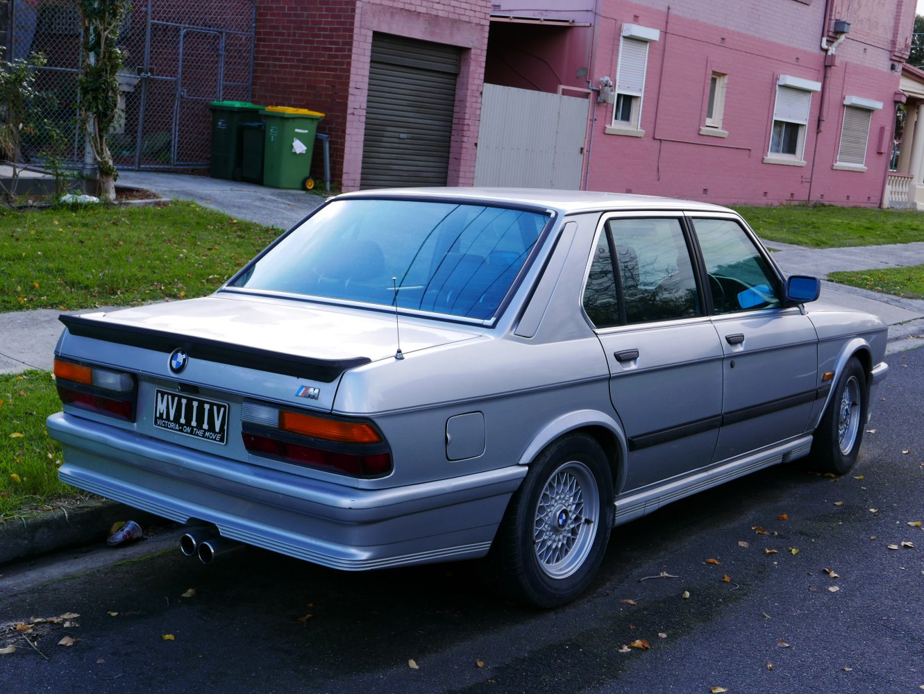 Rear view of a classic sedan with M spoiler and dual exhaust