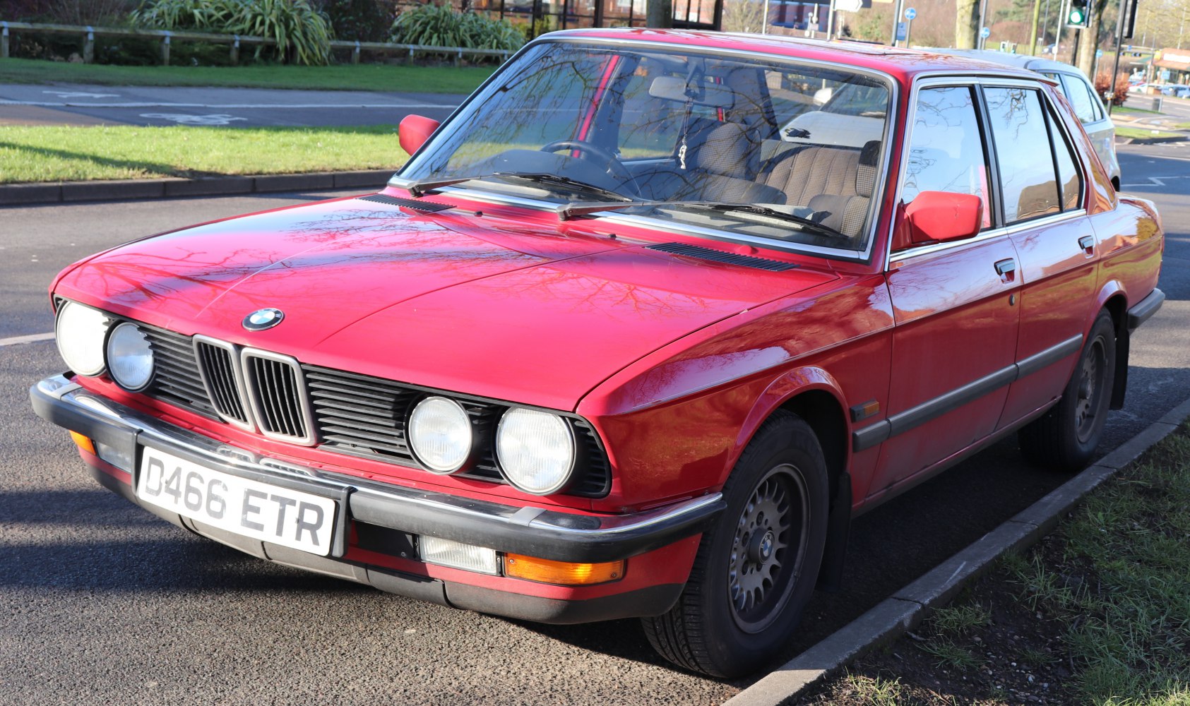 Red vintage sedan with round quad headlights and classic wheel design.