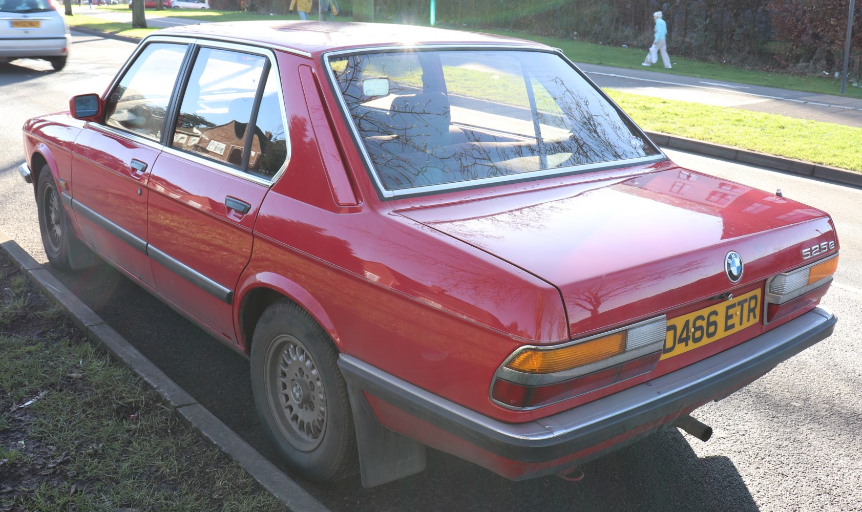 Rear side view of red classic vintage sedan with distinctive taillights and boxy design