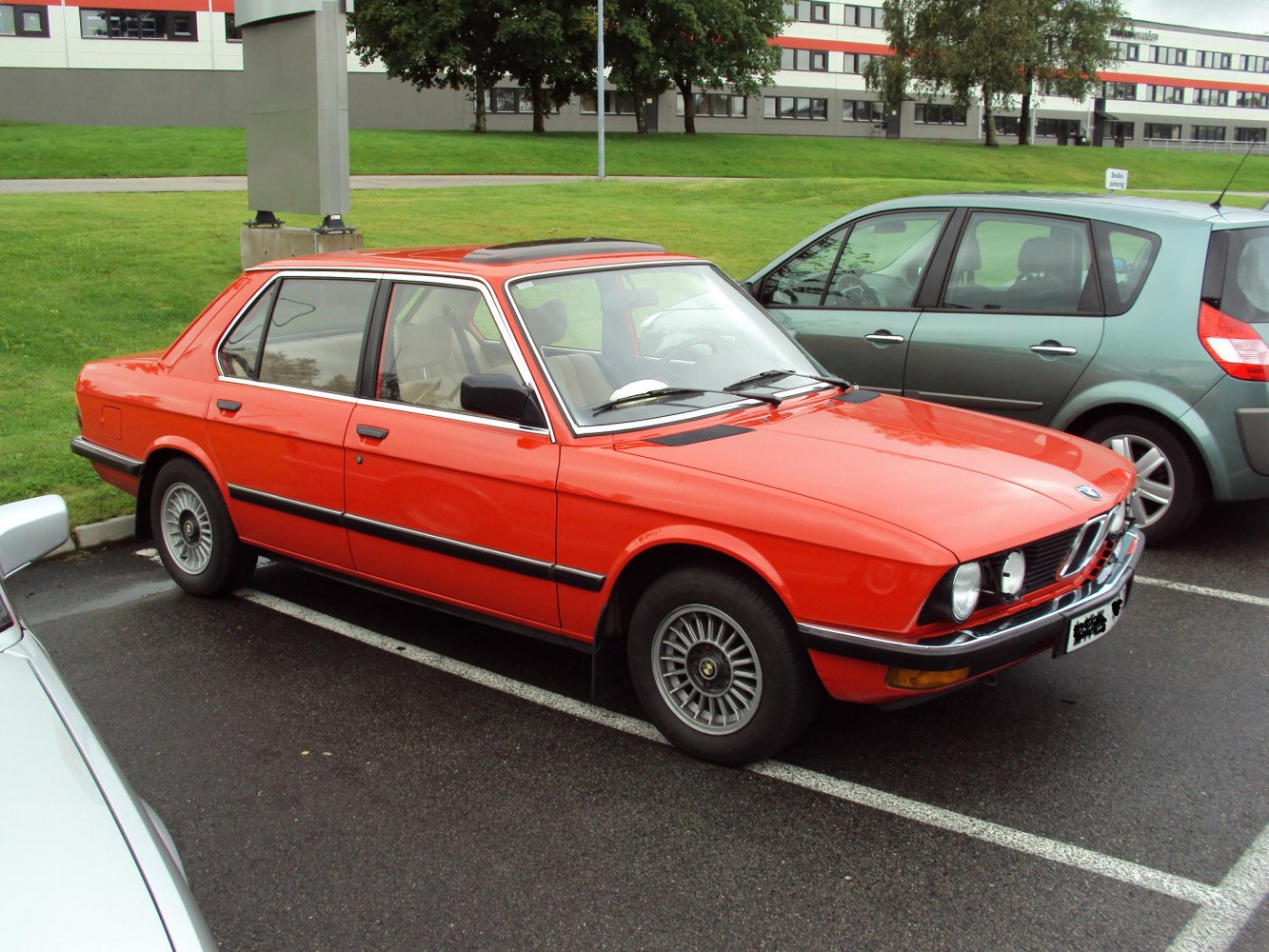 Red four-door sedan with alloy wheels and sunroof