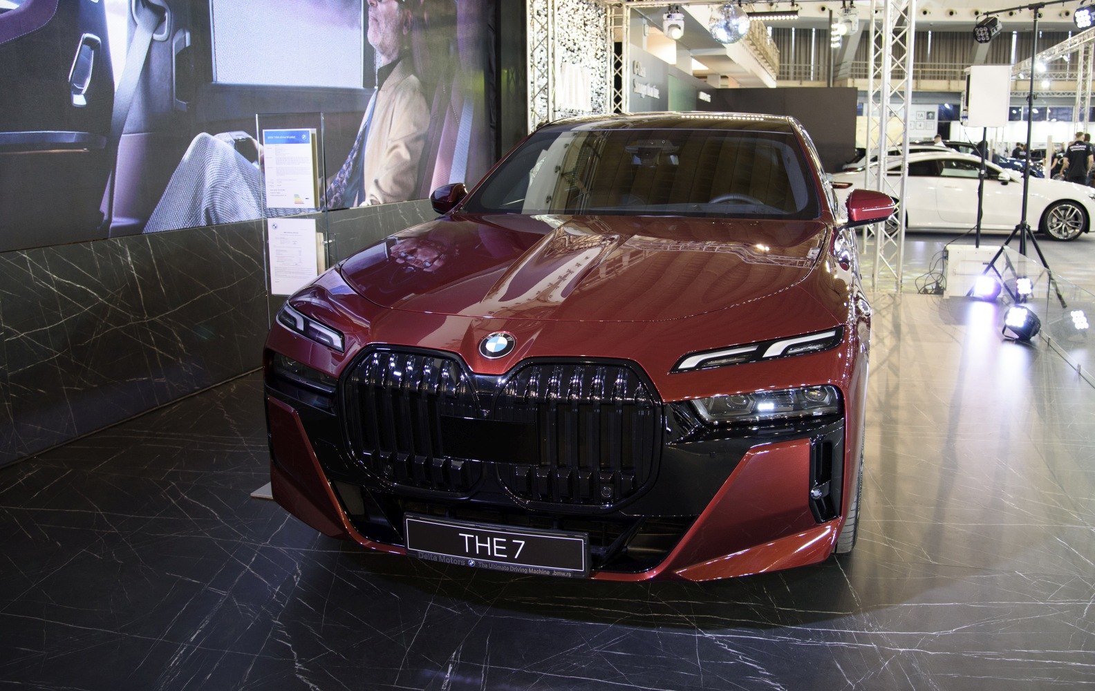 Large kidney grille and slim dual-layer headlights on red luxury sedan front