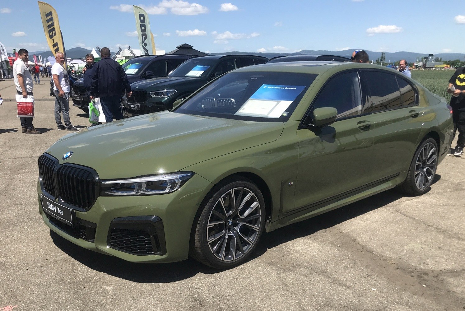 Luxury sedan with sleek front grille and alloy wheels in olive green.