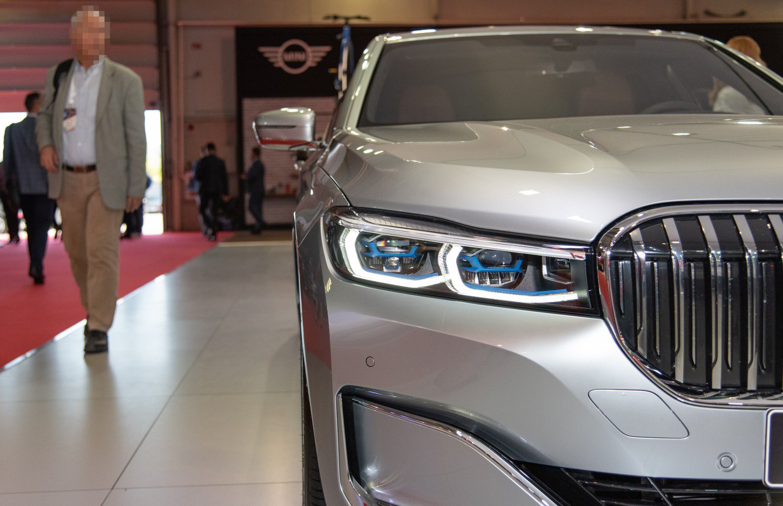 Close-up of modern LED headlights and chrome grille on luxury sedan front.