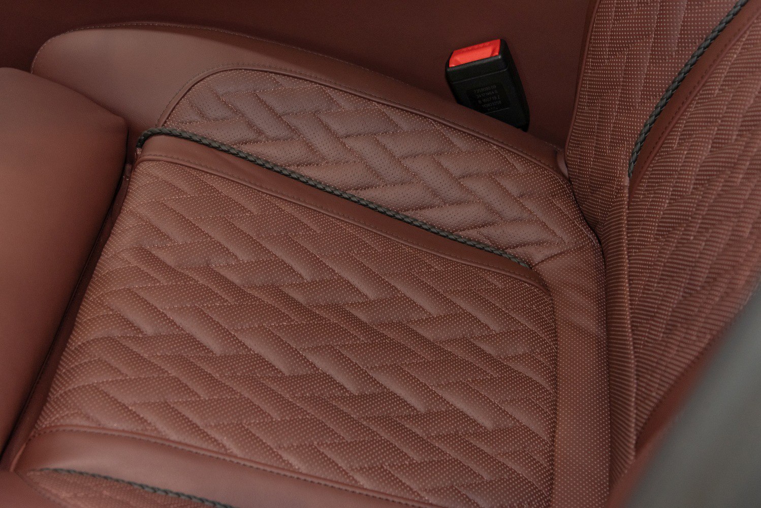 Brown leather seat with detailed stitching and piping
