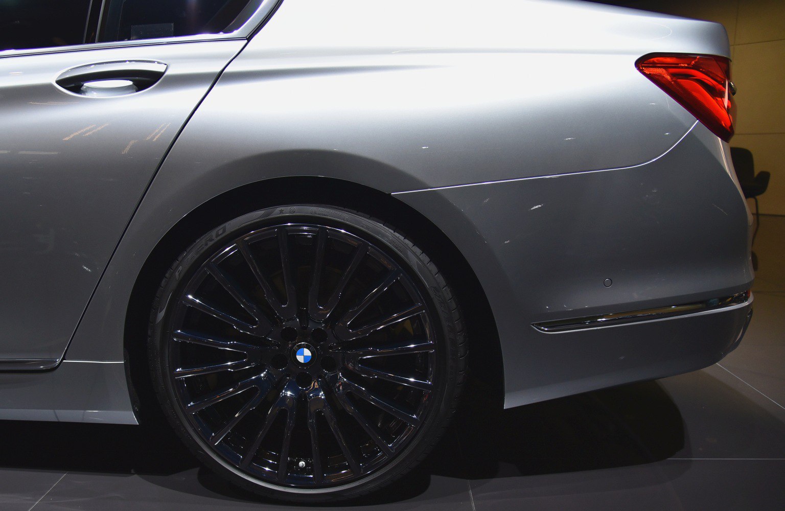 Close-up of rear wheel and side panel with black alloy rim and silver body.
