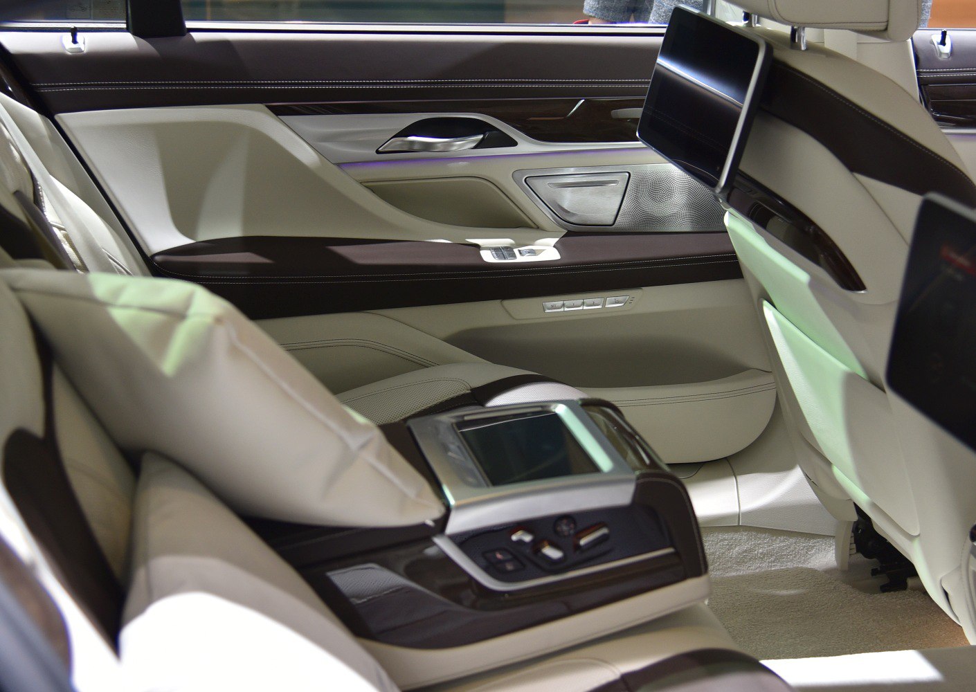 Luxury rear seat interior with touchscreen controls and entertainment screens