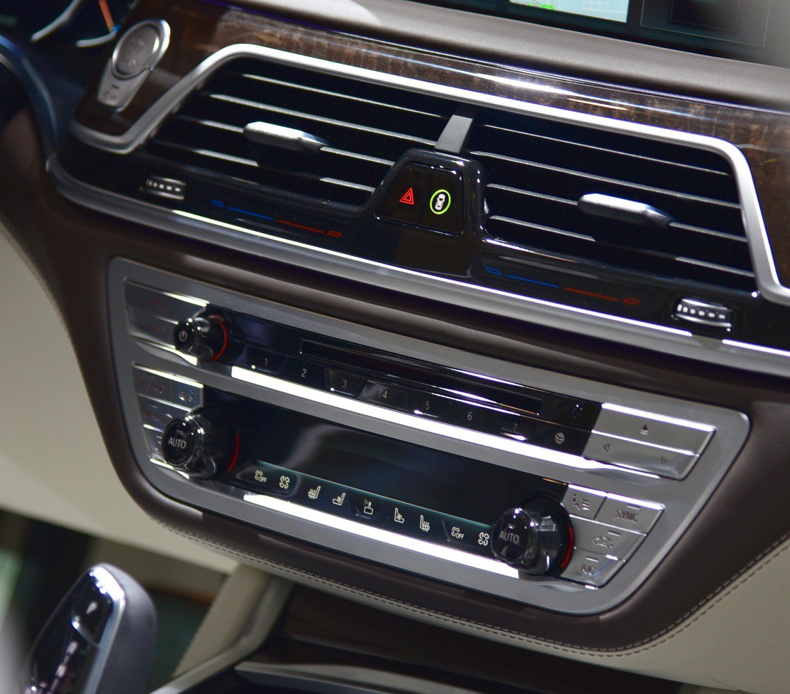 Close-up of dashboard air vents and climate control panel with knobs.