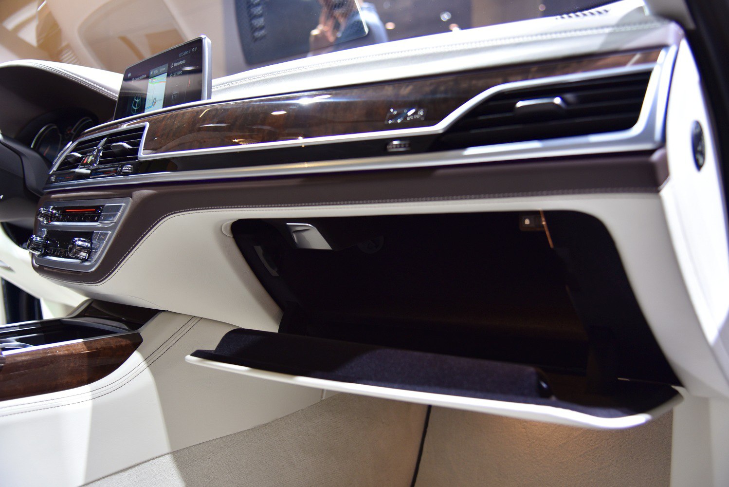 Luxury car glove compartment and dashboard with wood trim and infotainment screen