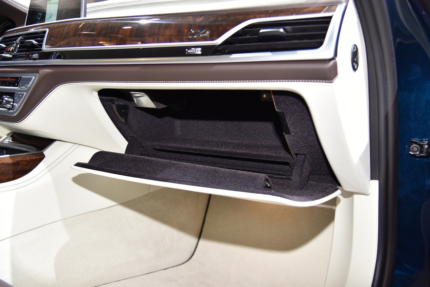Open glove compartment with wood trim and stitched leather detailing