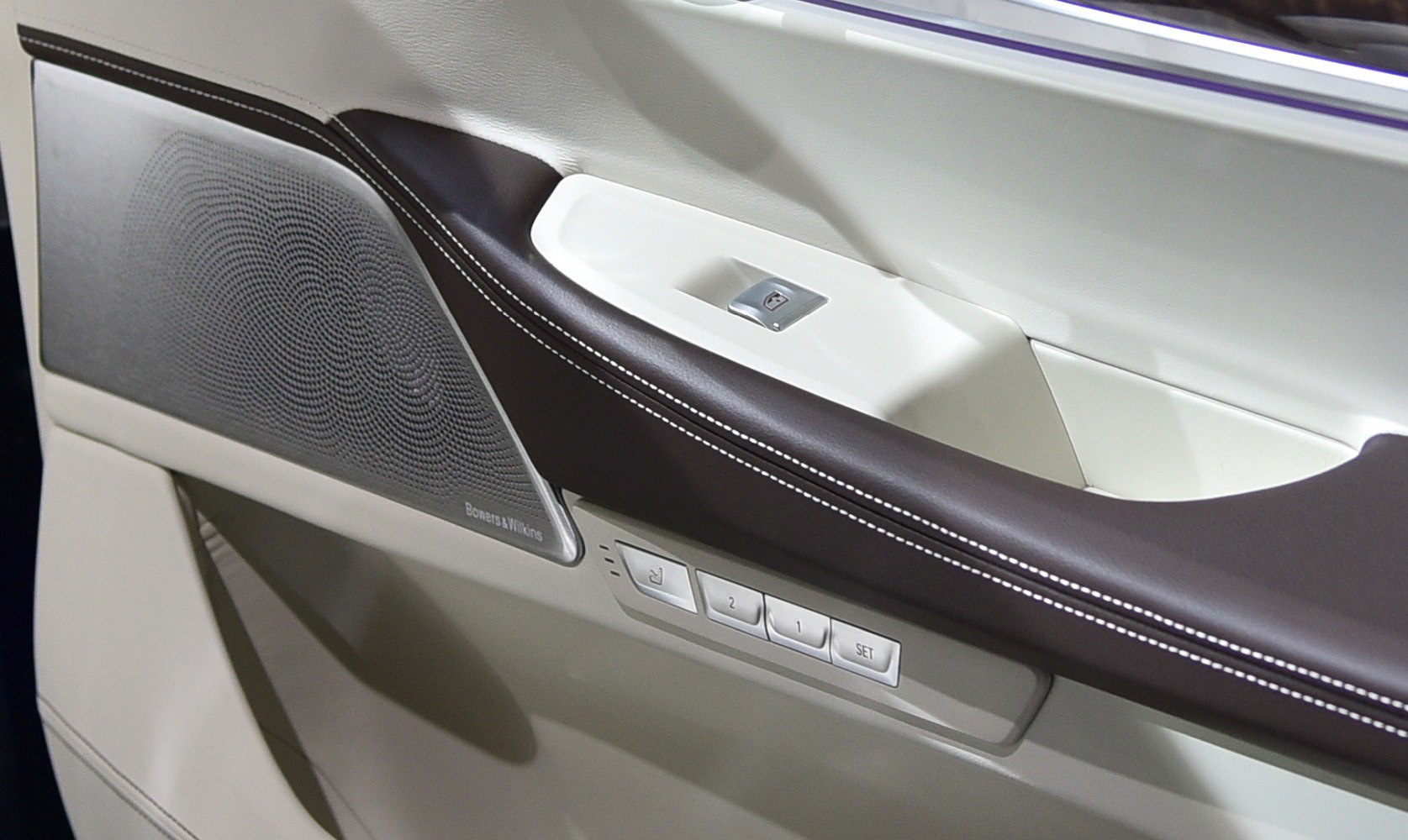 Luxury car interior door panel with speaker and seat memory buttons