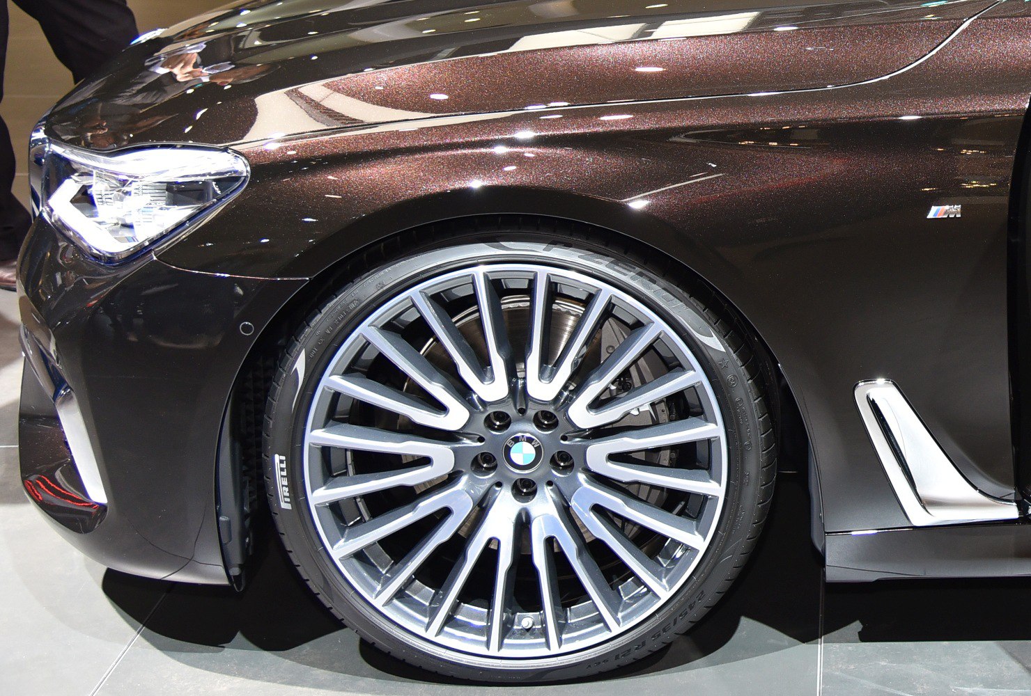 Close-up of luxury multi-spoke front wheel and headlight