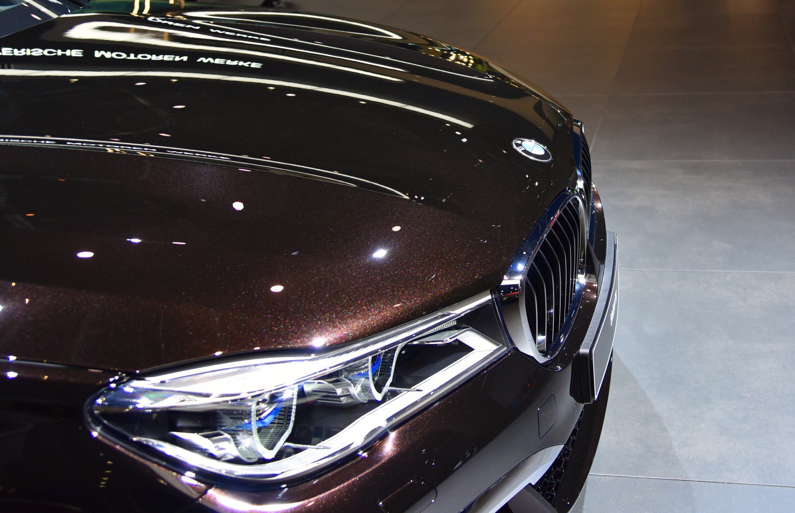 Close-up of a car's front headlight and kidney grille.