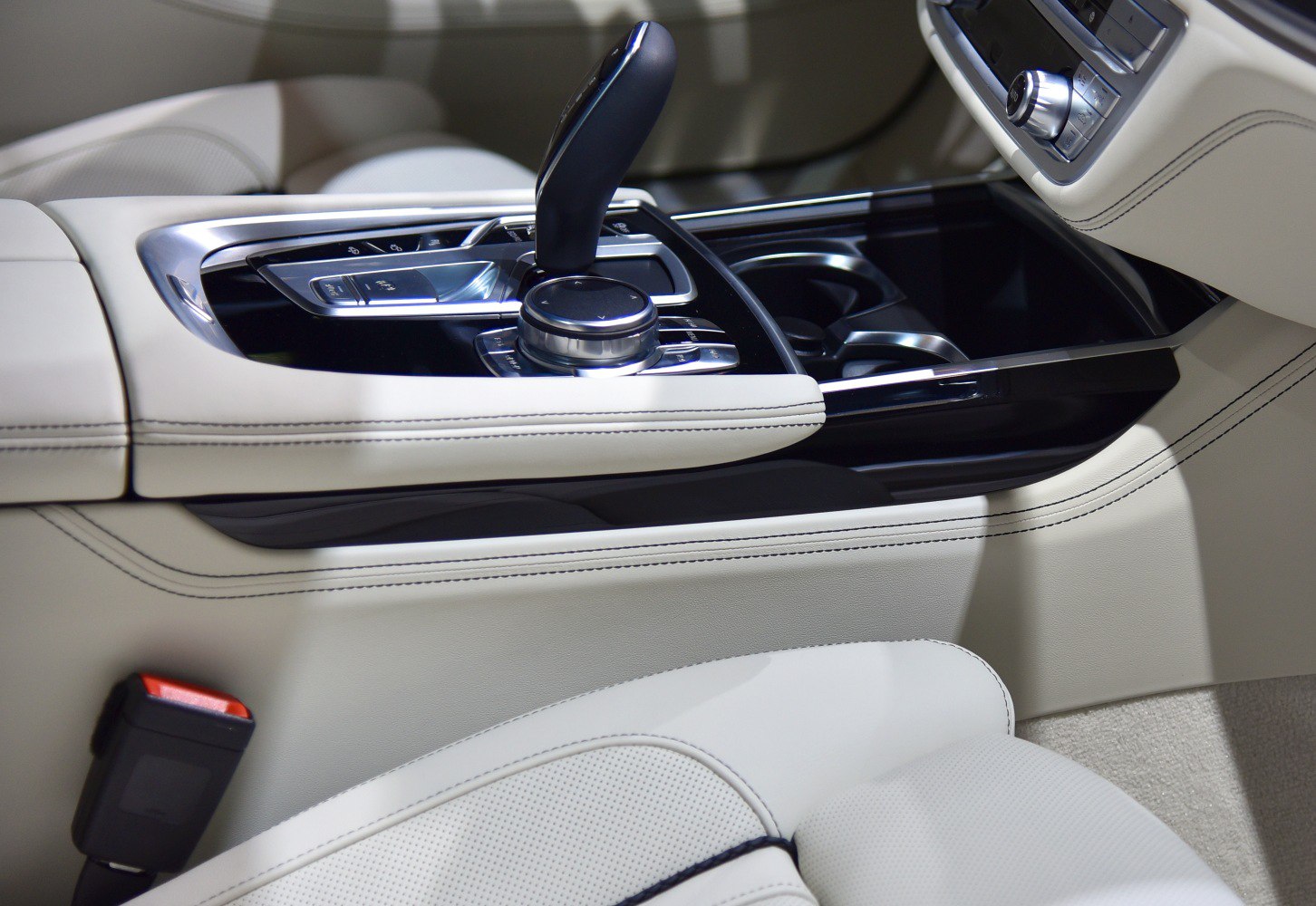Luxury car gear shift and control dial on center console with leather upholstery