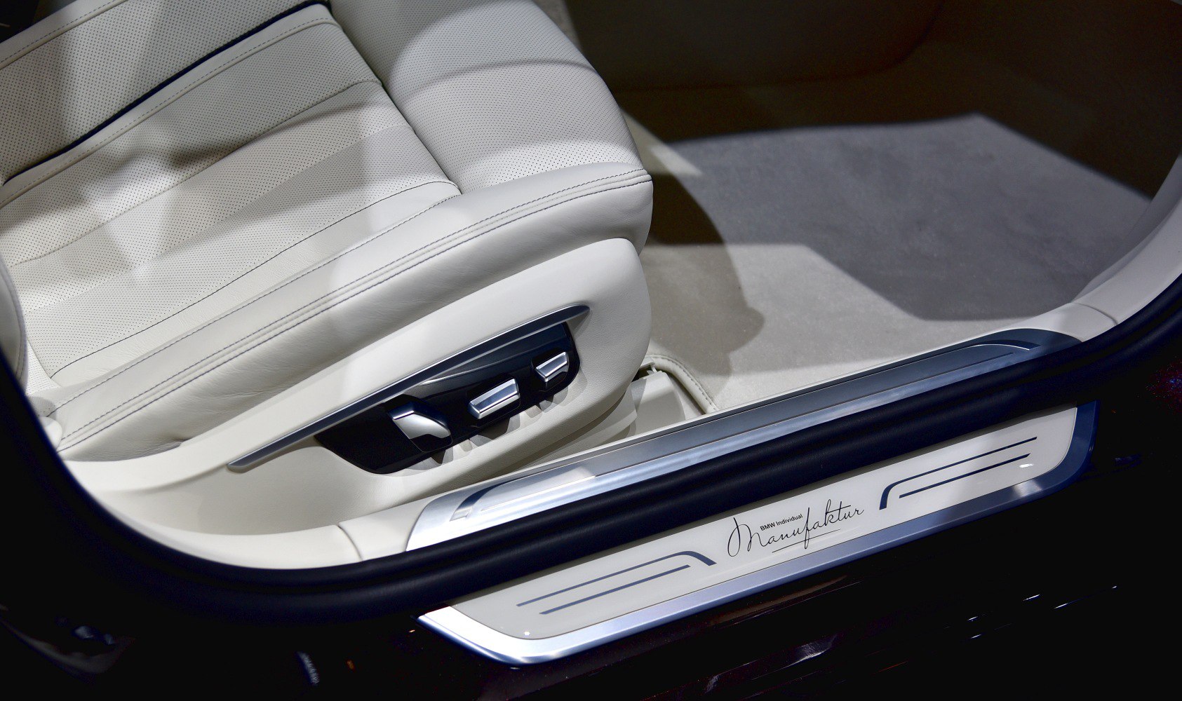White perforated leather seat with electronic controls and BMW Manufaktur door sill.