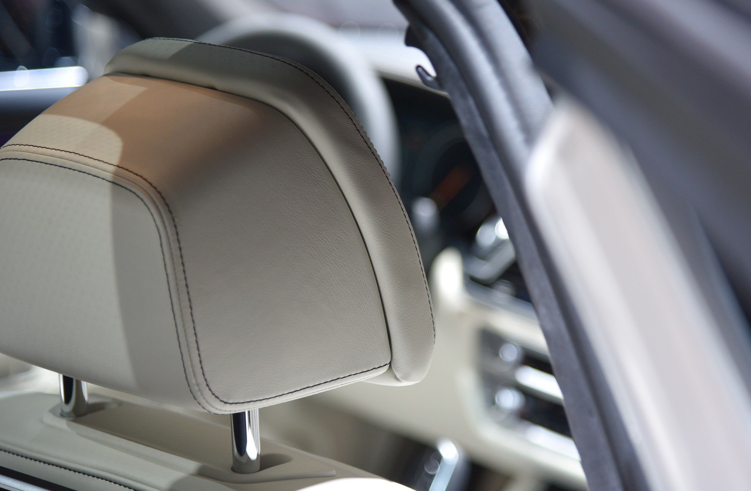 Close-up of beige leather headrest with detailed stitching