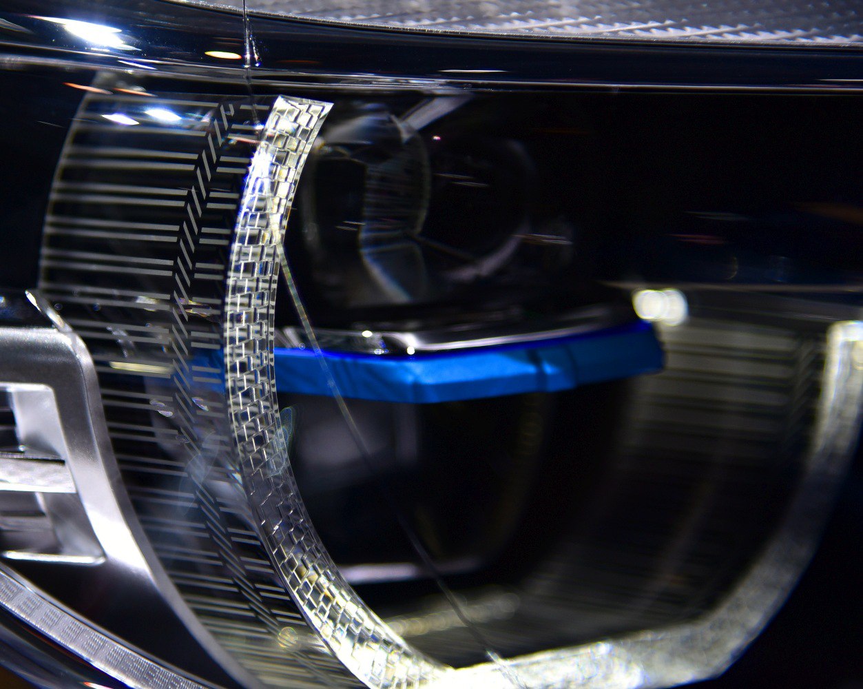 Close-up of a modern LED headlight with distinctive sculpted lens and reflective elements.