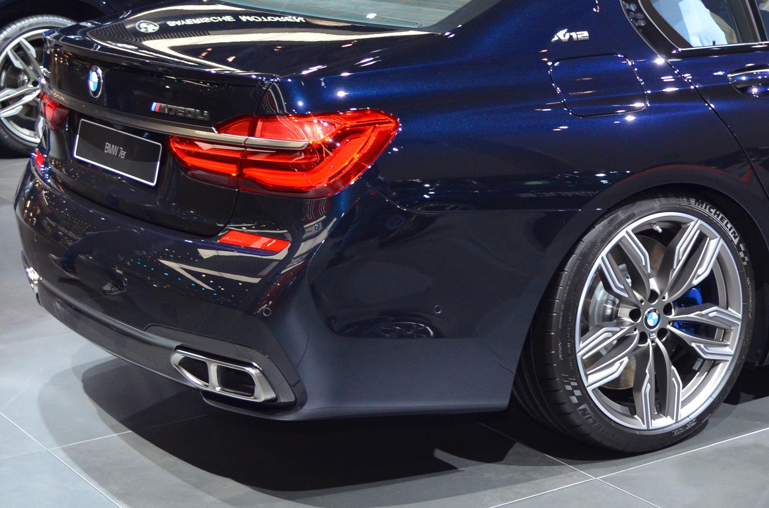 Rear section with V12 badge, tail lights, and alloy wheel closeup